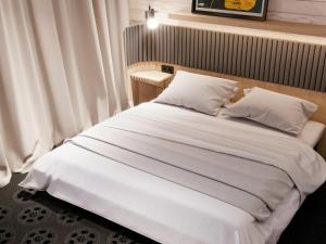 a bed with a white comforter and pillows at ibis Styles Arras Centre in Arras