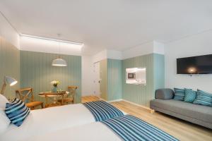 a hotel room with a bed and a couch at 7 Bridges Estúdios- Porto-houses and suites in Porto