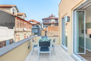 ポルトにある7 Bridges Estúdios- Porto-houses and suitesのバルコニーにテーブルと椅子が置かれたバルコニー