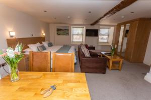 Habitación de hotel con cama y sala de estar. en Porthole Suites en Saint Aubin