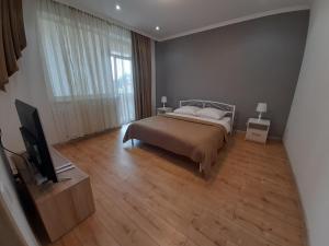 um quarto com uma cama e uma televisão de ecrã plano em New !!! Modern Lux apartment in the city center with a terrace em Mukacheve