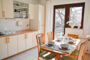 a kitchen with a wooden table with chairs and a dining room at House Marin - whole house in Maribor