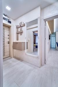 a living room with a large mirror and a hallway at Апартамент S Apart in Varna City