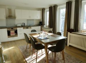 a kitchen with a dining room table and chairs at Villa am Deich in Westerdeichstrich
