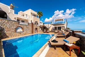a villa with a swimming pool and a house at Hotel Thira in Fira