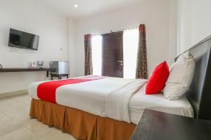 Postel nebo postele na pokoji v ubytování Capital O 1666 Grand Pudjawan Hotel Near Kuta Beach + 37 fotografií