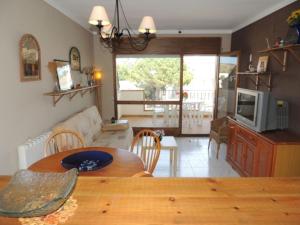 een keuken en een woonkamer met een tafel en een televisie bij Jardins 3 4 1 2 Roses - Immo Barneda in Roses