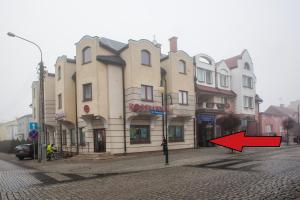 a building on a street with a red arrow at City Center Apartments Lofty z klimatyzacją in Augustów