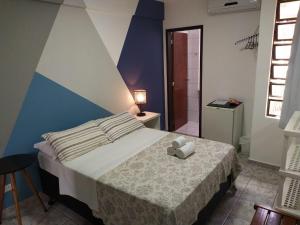 Un dormitorio con una cama con un osito de peluche. en Hotel Nautico, en Guaratuba