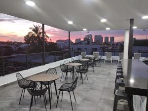 un toit-terrasse avec des tables et des chaises et un coucher de soleil dans l'établissement Venecia 262, à Puerto Vallarta
