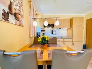 a kitchen with a wooden table and chairs at Dünenresidenz Heideweg 7a in Ostseebad Karlshagen