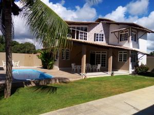 a house with a swimming pool in front of it at Casa das Conchas Ipioca in Maceió