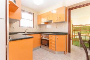 a kitchen with orange cabinets and a sink at Playa Flamenca Splendid apartment on the beach in Alicante