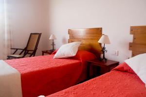 - une chambre avec 2 lits avec des draps rouges et une tête de lit en bois dans l'établissement Casa Celia - Casitas Las Abuelas - Relax rural, à Breña Alta