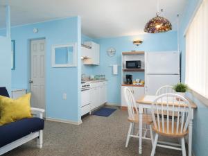 - une cuisine avec des murs bleus, une table et des chaises dans l'établissement South Beach Inn - Cocoa Beach, à Cocoa Beach