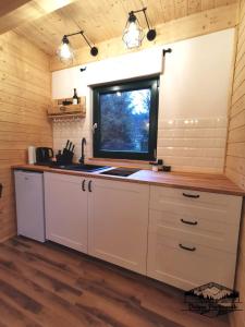 a kitchen with a sink and a window at Domki Wisła Dolina Partecznik in Wisła