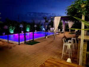 una piscina por la noche con luces moradas en Casa Rural Mirador del Sol, en Villalba del Alcor