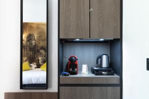 ein Zimmer mit einem Zimmer mit einem Bett und einer Küche in der Unterkunft SOWELL HOTELS L'Olivier in Arles