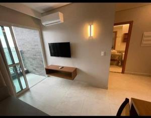 ein Wohnzimmer mit einem Flachbildfernseher an der Wand in der Unterkunft Apartamento em Salinas Exclusive Resort in Salinópolis