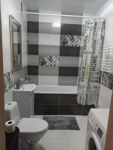 La salle de bains est pourvue de toilettes, d'un lavabo et d'une baignoire. dans l'établissement Апартаменти люкс в центрі, на вулиці Набережна,10 з парковкою, à Loutsk