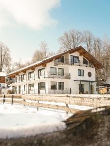 an apartment building in the snow with a fence at Hotel verWeiler in Fischen