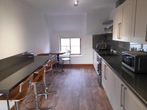 cocina con encimeras negras y mesa en Travellers Rest Apartment, en Beverley