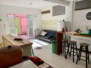 a kitchen and living room with a couch and a table at AymuraY Hostel e Pousada in Penha