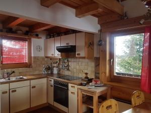 eine Küche mit einem Herd, einem Waschbecken und einem Fenster in der Unterkunft grosses Ferienhaus mit Sauna im Skigeb. Obersaxen in Obersaxen