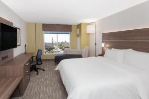 ein Hotelzimmer mit einem großen Bett und einem Schreibtisch in der Unterkunft Holiday Inn Express & Suites Downtown Ottawa East, an IHG Hotel in Ottawa
