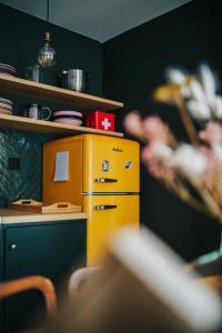 a kitchen with a yellow refrigerator next to a shelf at Sosnowy Taras in Koszele