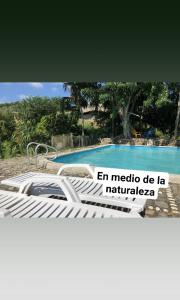 a bed in front of a swimming pool at Hostal Brisas del Campo in Guachaca