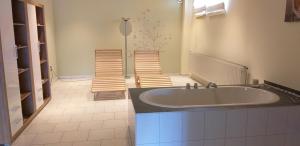 布賴騰布倫的住宿－Pension Berghof，一间带大浴缸和两把椅子的浴室