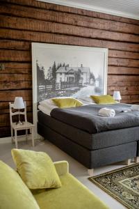 a bedroom with a large bed with a picture on the wall at Vanha pappila Hetki Oy in Ähtäri
