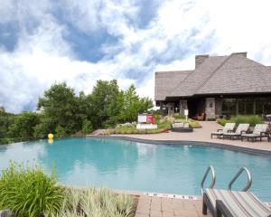 a swimming pool with two benches in front of a building at Muskoka Bay Resort in Gravenhurst