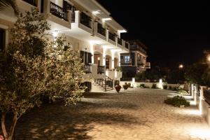 a large white building with a courtyard at night at Sunrise Hotel in Samos