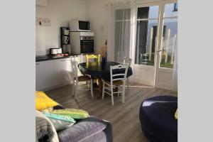 ein Wohnzimmer mit Tisch und Küche in der Unterkunft Maison de vacances en bordure de mer ! in Batz-sur-Mer
