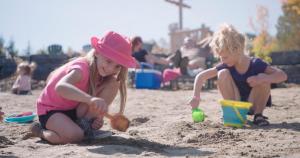 two young girls playing in the sand on the beach at Station Touristique Duchesnay - Sepaq in Sainte-Catherine