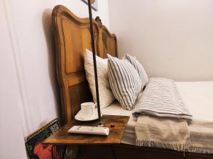 a bed with a table with a remote control on it at Serce miasta in Kazimierz Dolny