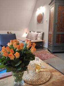 un vase de fleurs orange sur une table dans le salon dans l'établissement Serce miasta, à Kazimierz Dolny