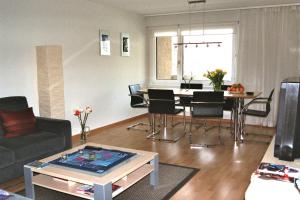 a living room with a couch and a table with chairs at Ferienwohnung Schaap-Müller in Andermatt