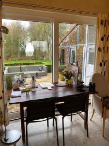 a dining room table with chairs and a large window at Vakantiewoning Jérôme in Heuvelland +33 photos