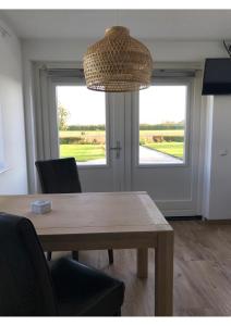 a dining room with a table and a large window at B&B De Spiegel - Genieten van rust en ruimte in Cothen