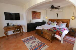 a bedroom with a bed and a desk and a television at Casa Mia Suites in San Miguel de Allende