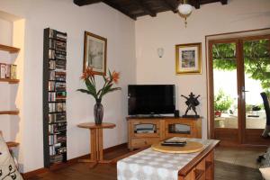 sala de estar con TV y mesa en Le Chat Botté - Vankantiehuis in Languedoc-Roussillion, en Routier