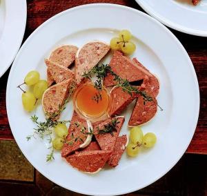 a plate of food with meat and grapes on a table at Osteria La Riva in Locarno