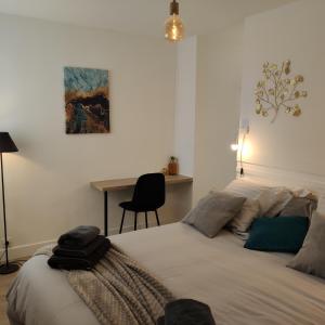 a bedroom with a bed with a desk and a painting at LE 21 Vue sur Mer in Concarneau