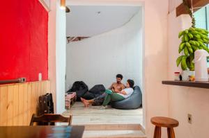 dwie osoby siedzące na podłodze w salonie w obiekcie Clan.Destino Hostel w mieście Ilhabela