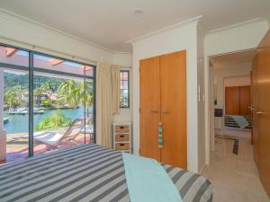 a bedroom with a bed and a view of the water at Amalfi - Pauanui Holiday Home in Pauanui