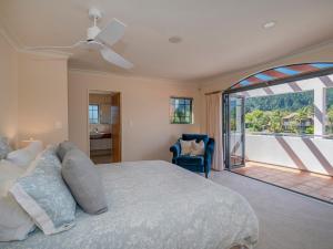 a bedroom with a large bed and a balcony at Amalfi - Pauanui Holiday Home in Pauanui