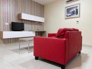 a living room with a red chair and a tv at Vista Point - Cast Renting in Msida